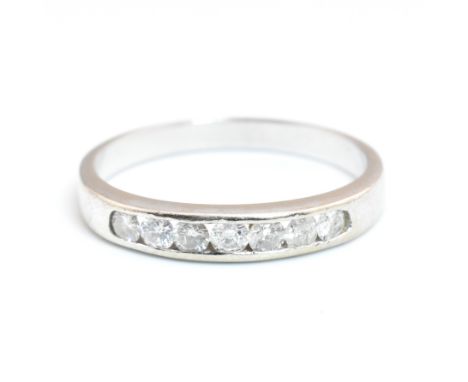 A hallmarked 9ct white gold and diamond half eternity ring. The 9ct white gold ring having seven channel set round brilliant 