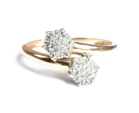 A hallmarked 9ct rose gold and diamond crossover ring. The ring having two clusters of round cut diamonds set in a crossover 