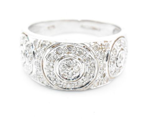 A hallmarked 9ct white gold and diamond ring. The 9ct white gold domed ring having three circles set with pave set diamonds t