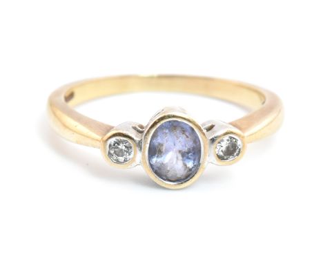 A hallmarked 9ct gold, amethyst and diamond three stone ring. The 9ct yellow gold ring having a central bezel set oval cut am