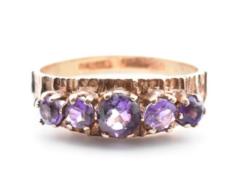 A 1970s hallmarked 9ct gold and amethyst five stone ring. The 9ct gold Modernist ring having five graduating round cut amethy