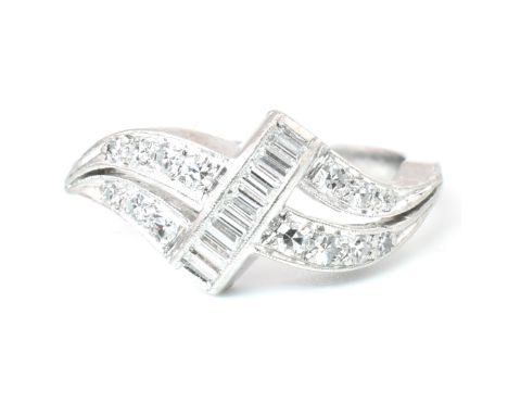 A 1930s platinum and diamond ring. The ring set with a central crossover of calibre cut baguette diamonds flanked by two rows