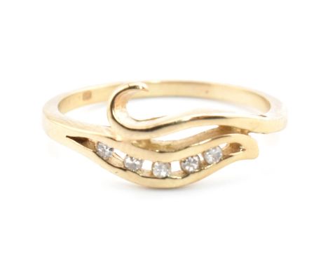 A hallmarked 9ct gold and diamond crossover ring. The 9ct yellow gold ring having a single row of five channel set round cut 