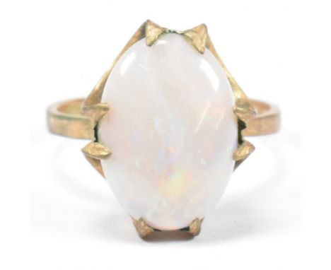 A hallmarked 9ct gold and opal ring. The 9ct gold ring having a double claw set oval opal cabochon set in a modernist mount. 
