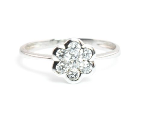 A hallmarked 18ct white gold and diamond flower cluster ring. The 18ct white gold ring having a principal round brilliant cut