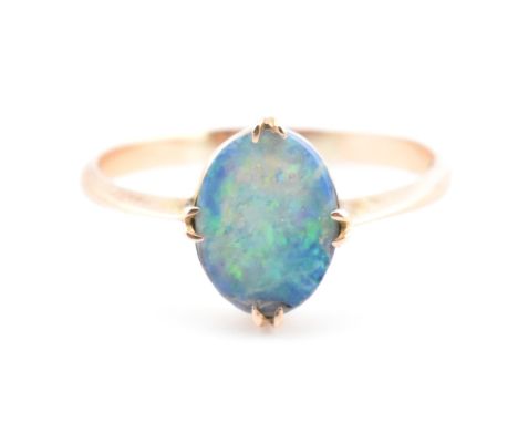 A 9ct gold and opal triplet ring. The ring set with a double claw set opal triplet to tapered shoulders. Marked 9ct to inner 