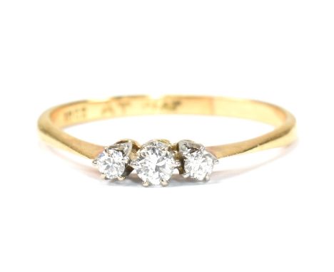 A 18ct gold, platinum and diamond trilogy ring. The ring set with three graduating round cut diamonds to tapered shoulders.&n