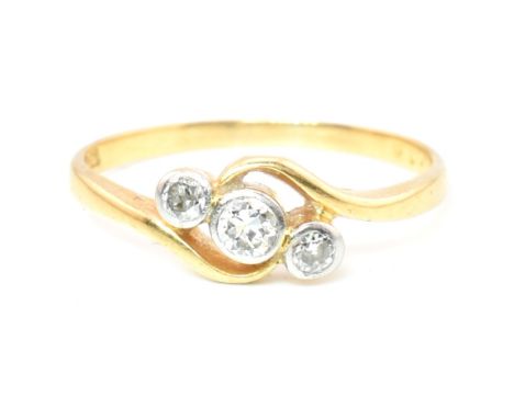 A cased 18ct gold and diamond three stone crossover ring. The 18ct yellow gold ring having three graduating bezel set round c