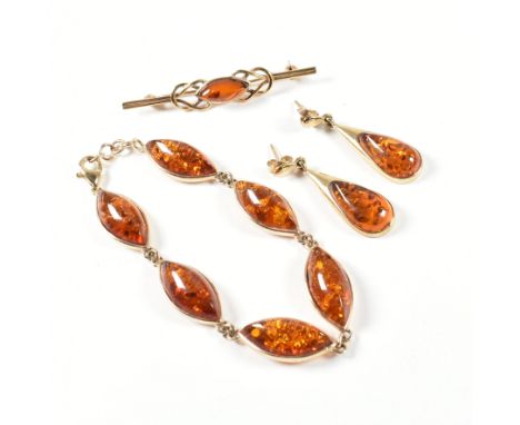A hallmarked 9ct gold and amber jewellery suite. The jewellery to include a hallmarked 9ct gold and amber bracelet with six m