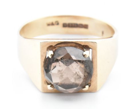 A hallmarked 9ct gold and smoky quartz signet ring. The 9ct yellow gold signet ring set with a single four claw set mixed cut