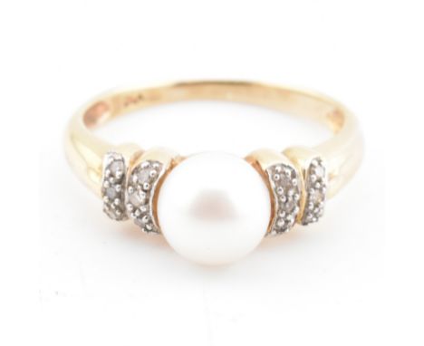 A hallmarked 9ct gold, diamond and cultured pearl ring. The 9ct yellow gold ring having a single round cultured pearl flanked