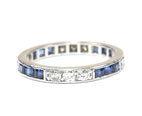 A white gold and platinum diamond and sapphire eternity ring. The full eternity ring having twelve channel set round cut diam