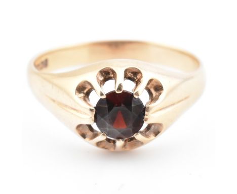 A hallmarked 9ct gold and red stone signet ring. The 9ct gold signet ring set with a round cut red stone in a pierced mount t