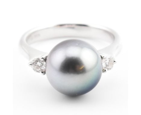 An 18ct white gold, Tahitian pearl and diamond three stone ring. The 18ct white gold ring having a central round black Tahiti