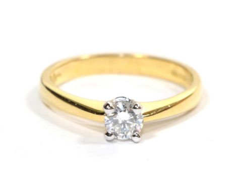 An 18 carat gold solitaire diamond ring, a round brilliant cut diamond in a white claw setting, to knife edge shoulders, esti