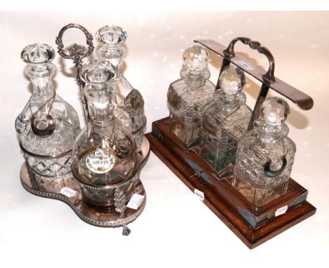 A silver plated three bottle decanter stand, with cut glass decanters; and a three bottle tantalus (decanters ill fitting)