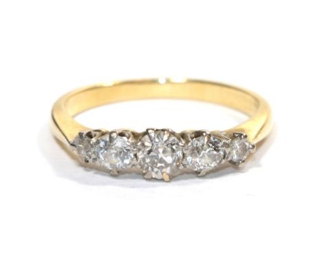 A five stone diamond ring, the old cut diamonds in white claw settings, to yellow knife edge shoulders on a plain polished sh