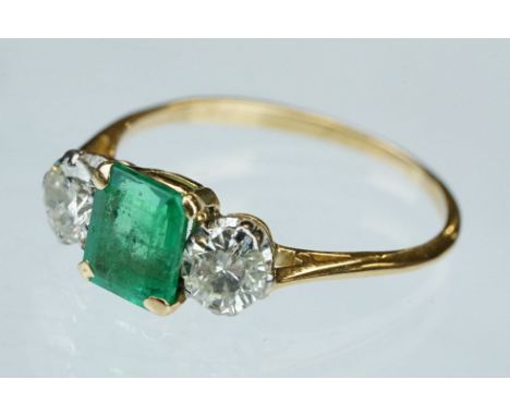 Emerald and diamond 18ct yellow gold three stone ring,  the rectangular mixed cut emerald measuring approx 7mm x 6mm, four cl