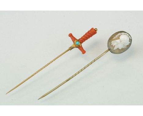 Late 19th century coral, turquoise and split pearl unmarked gold stick pin modelled as a sword hilt, carved coral, gold mount