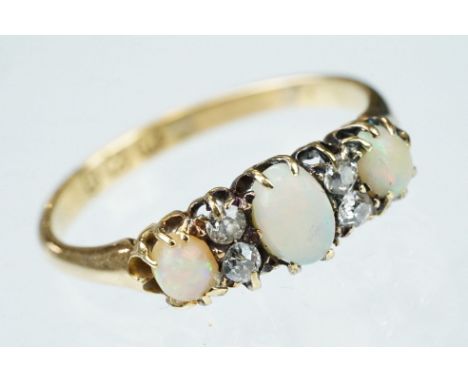 Opal and diamond 18ct yellow gold ring, three graduated oval cabochon cut precious white opals, indigo, green and red play-of