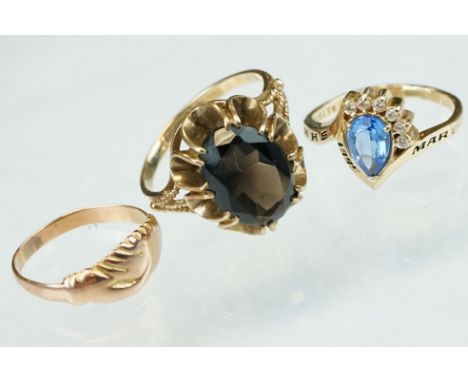 Smoky quartz 9ct yellow gold ring, size Q; rose metal ring of clasped hands, ring size K; and a blue stone and white stone 14