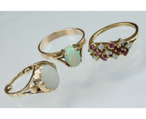 Opal 9ct yellow gold ring, the oval cabochon cut opal displaying violet, indigo, green, orange and red play-of-colour, four c