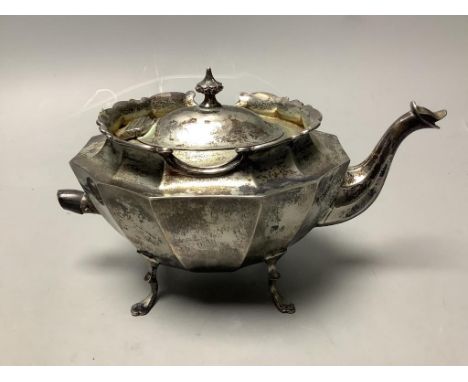   A late Victorian small silver teapot, of oval twelve-sided formon outswept paw feet, having raised shaped rim, zoomorphic s