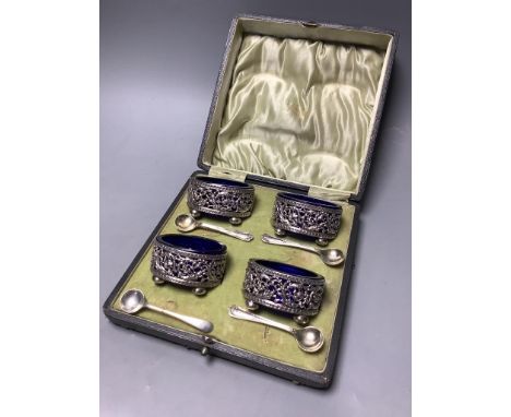   A cased set of four  Edwardian, pierced silver oval salts, with blue glass liners, Sheffield, 1904 and four associated spoo