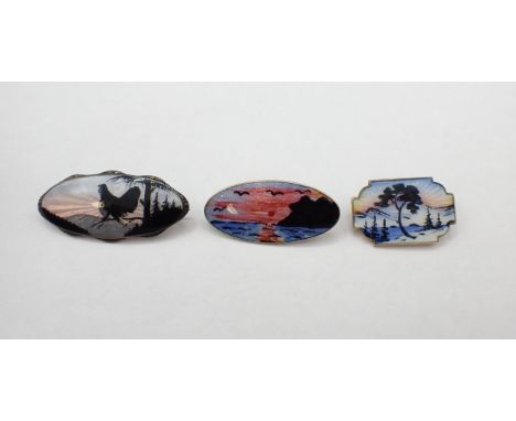 Three Norwegian silver and enamel Silhouette Brooches depicting; cockerel 41mm wide, coastal sunset 35mm wide and snowy lands