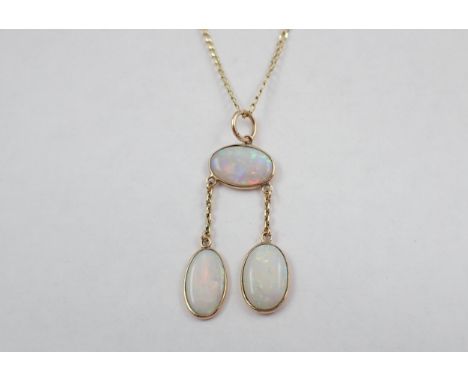 An Opal Négligée Necklace spectacle-set oval stone suspending two drops each set further stone on fine 9ct gold chain 