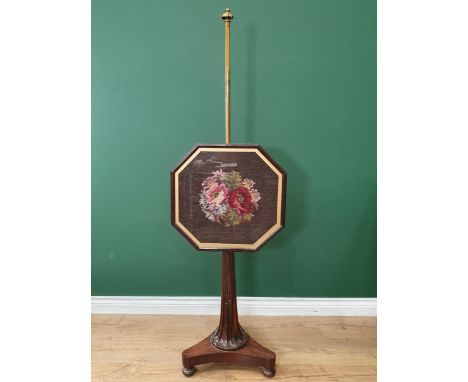 A 19th Century rosewood Pole Screen with brass bar supporting the octagonal tapestry panel with stop-fluted tapering column a