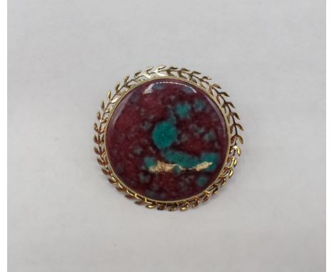 A Kensington Art Brooch the circular purple and turquoise enamel plaque in leafage yellow metal frame, 35mm diameter 