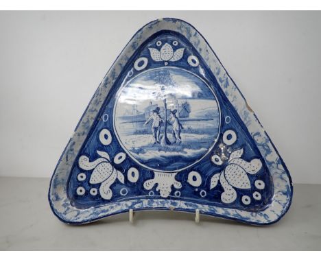 An unusual Delft triangular Stand painted circular reserve of two figures beside a tree, church beyond, shell gallery on thre
