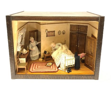 A 1/12th scale diorama of a cottage bedroom, depicting an elderly couple, he in bed, her by the door with cup in hand, the in