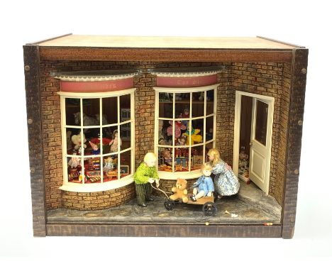 A 1/12th scale diorama of a toy shop window, depicting three children outside 'Adelaide's Toy Shop', the windows displaying a