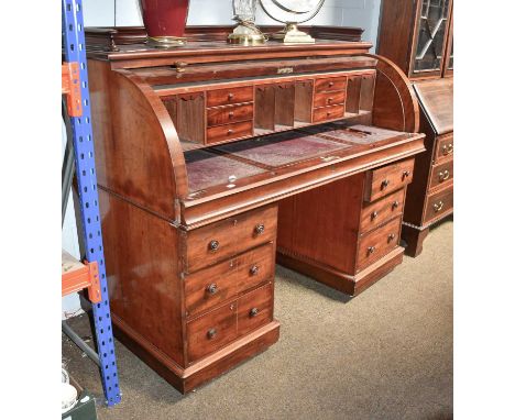 A Victorian Mahogany Roll-Top Pedestal Desk, galleried top over drum form front, opening to reveal fitted interior with leath