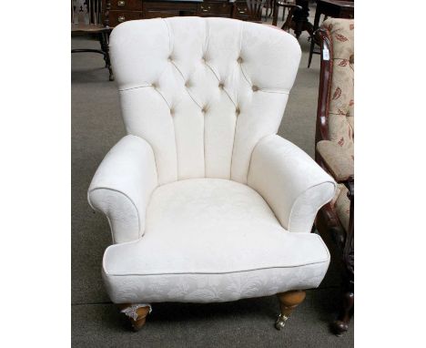 A Modern Button Backed Upholstered Armchair, turned supports and brass castors