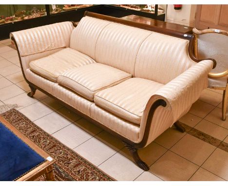 A Regency-Style Mahogany-Framed Three Seater Sofa in Striped Upholstery, with outscrolled arms, closely reeded apron, raised 