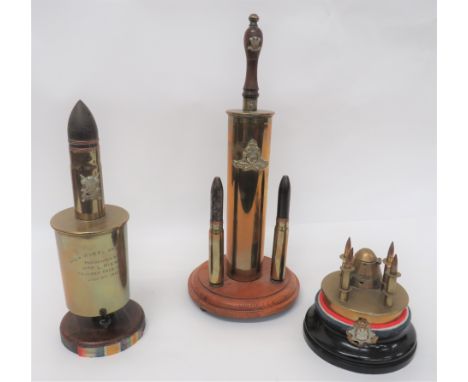 Three Various Trench Art Itemsconsisting shell base with bullet pen holder and rear fuse head inkwell.  All on a wooden base 