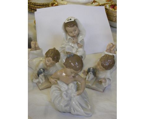 Four Nao figures of children in night clothes reading and playing.