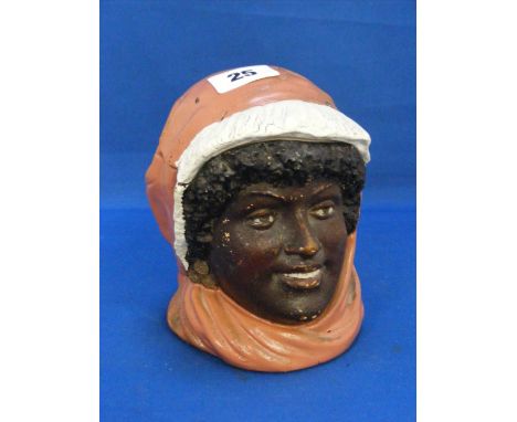 An Austrian ceramic tobacco jar depicting a smiling black female wearing orange hood and scarf.