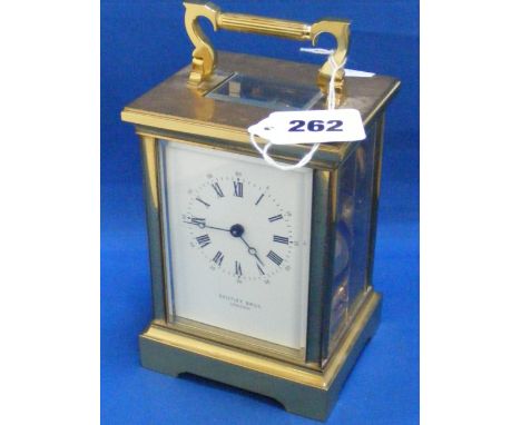 A four glass brass carriage clock striking on a bell, the white enamel face marked Bentley Bros. London.