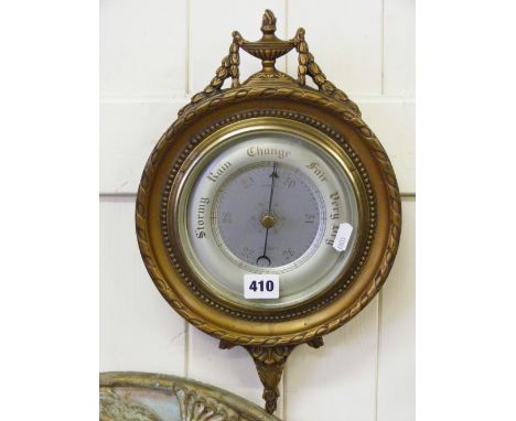 A wall barometer in ornate gilt case.
