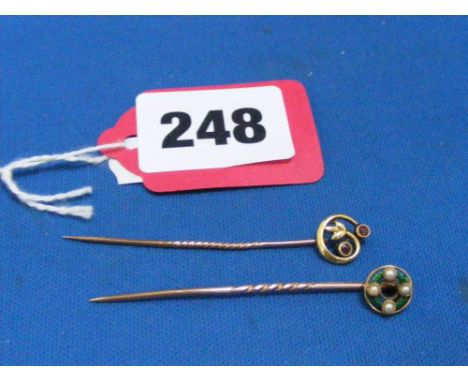 A 15K gold tie pin with inner circle of green enamel below four seed pearls, plus a 9ct gold pin set with two rubies.
