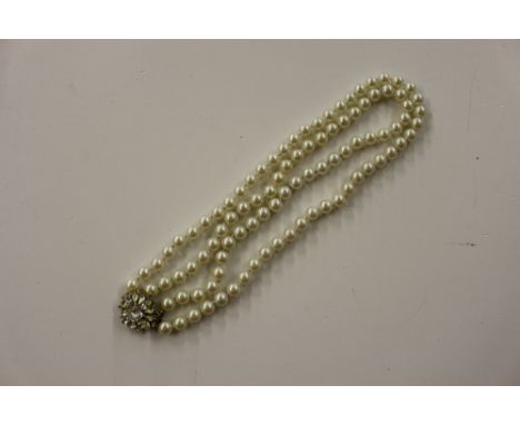 A simulated pearl necklace with white stone set clasp