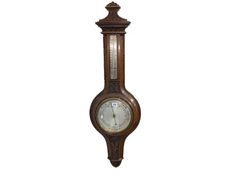 Carved mahogany aneroid barometer having silvered dial.
