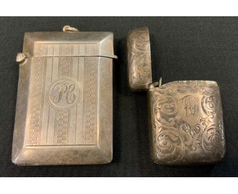A silver vesta case, engraved and chased with scrolling foliage, c.1900;   another engine turned in lines 