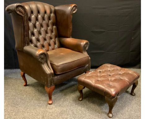 A button wing back chair, deep button back, cabriole legs;  conforming foot stool 