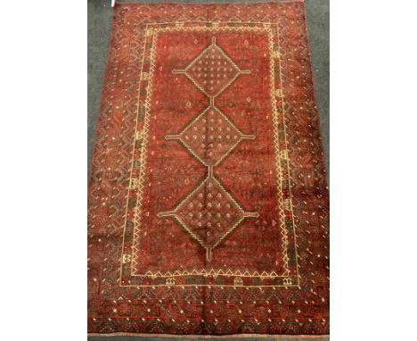 A fine Persian Shiraz woolen rug / carpet, woven with a triple row of medallions within a large central field, in shades of d