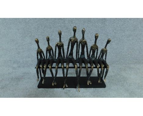A moulded figure group, a row of figures on a bench, Giacometti style H. 36 W. 39 